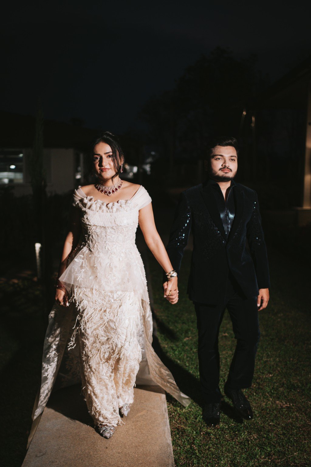 Om and Hima holding hands on a night-time walk